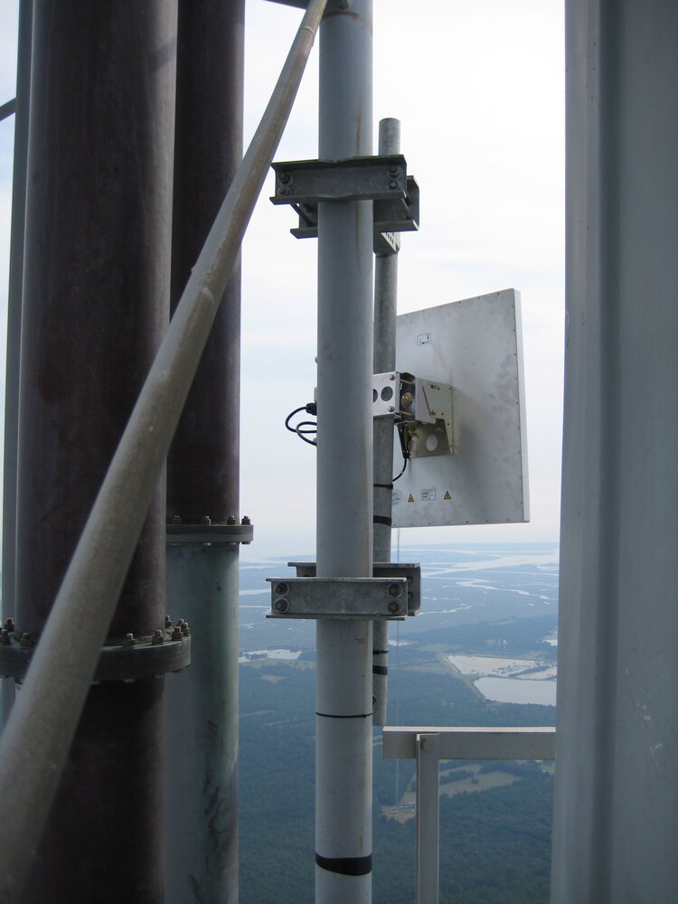 Custom antenna mounting hardware installed high on a tower